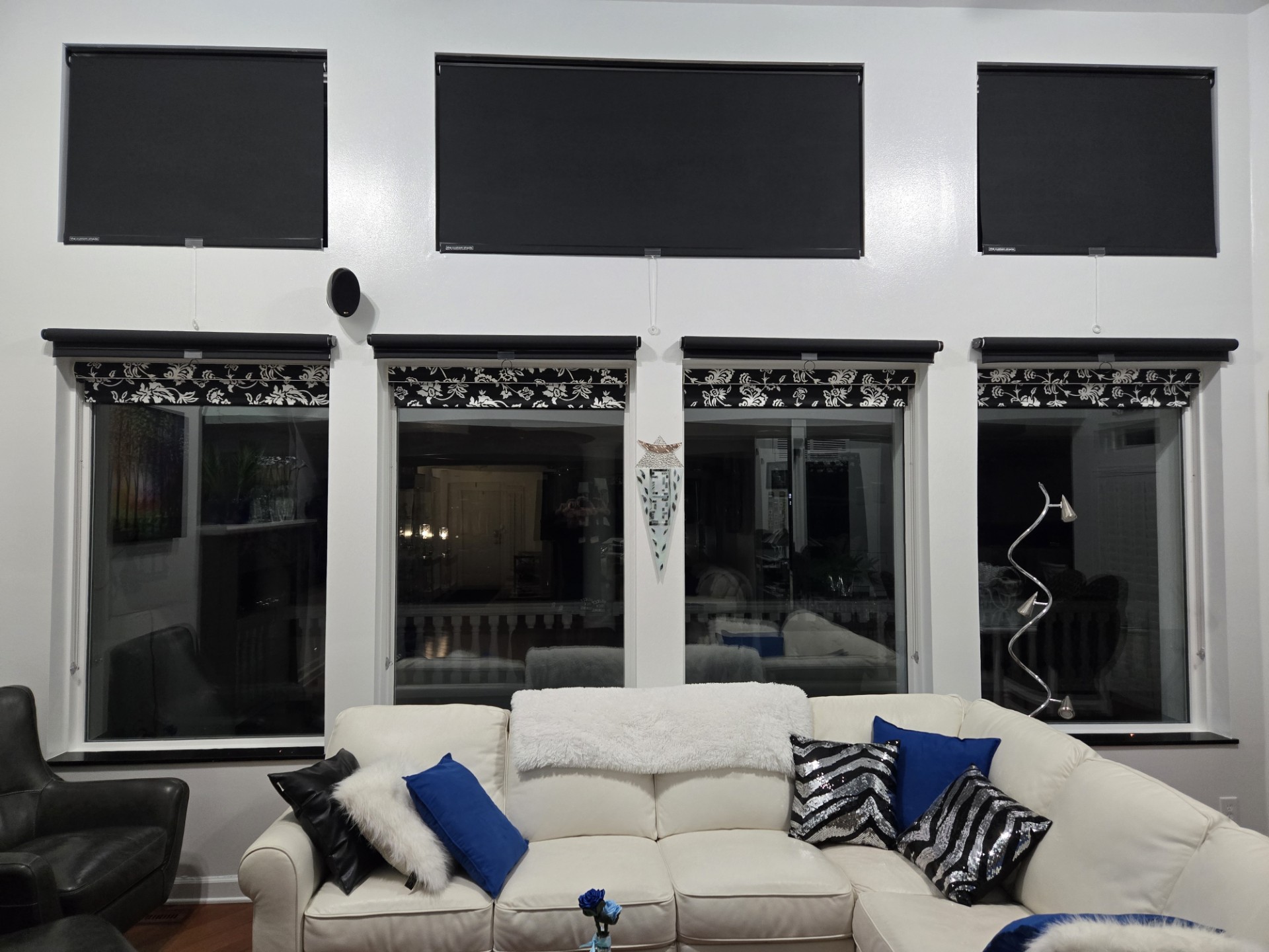 Photo of custom solar screen shades in a living room at night