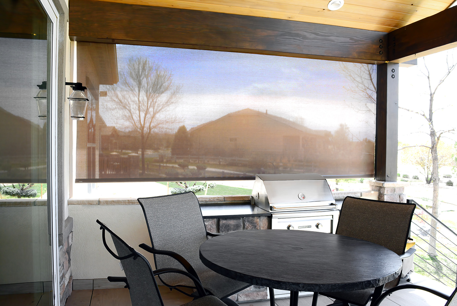 black solar screen roller shades mounted on tall windows in entryway