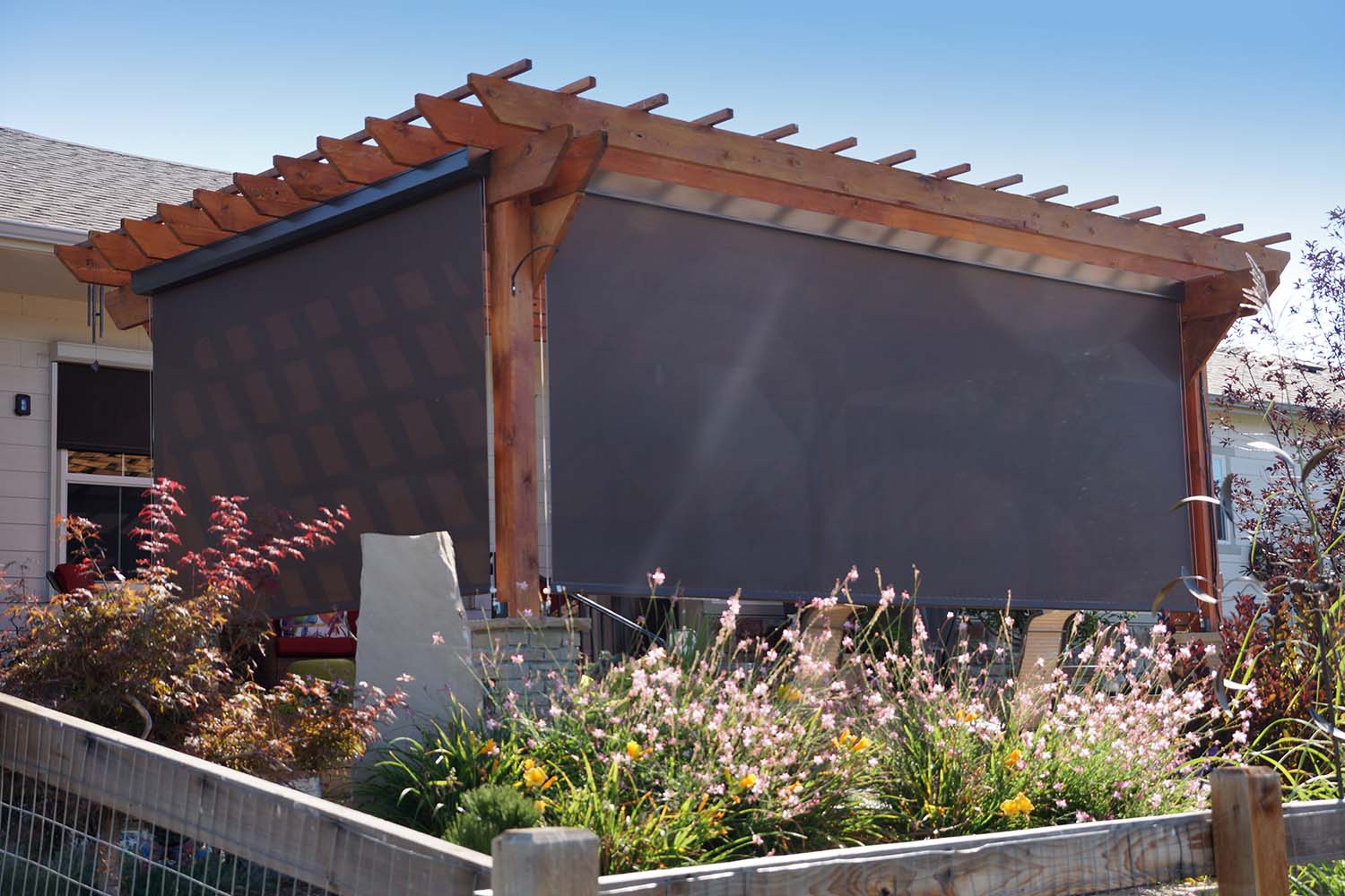 custom exterior patio roller shade mounted on residential pergola